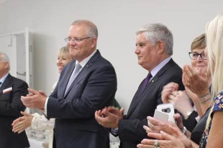 Two men and a woman smiling and clapping