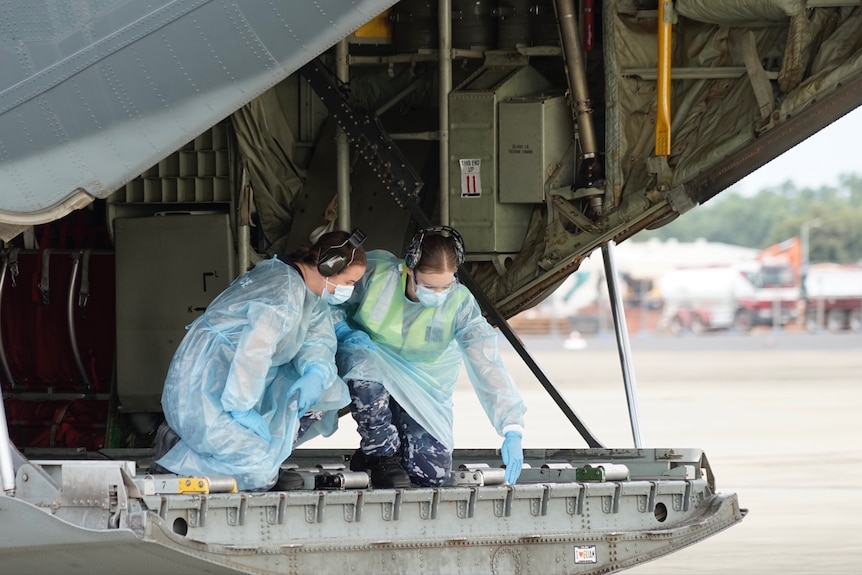 Two AUSMAT team members on the military aircraft.