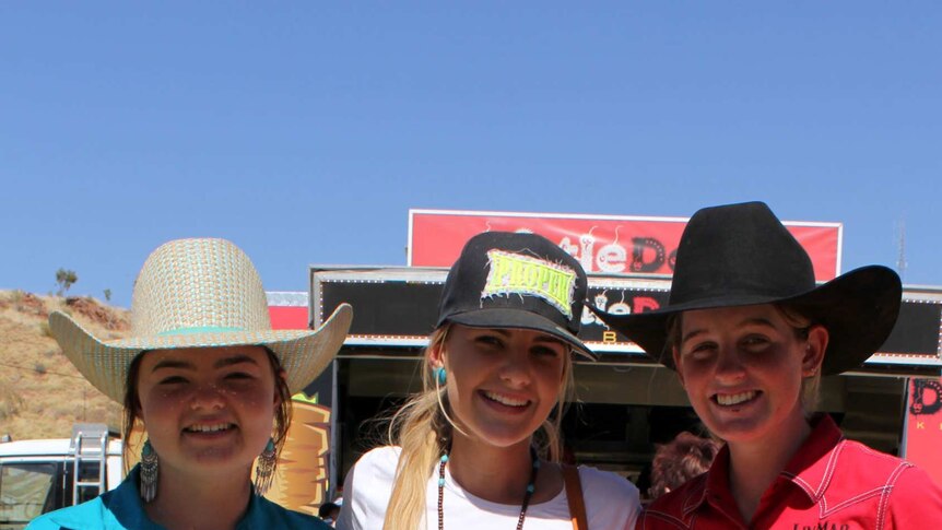 Three girls dressed in western wear at the Isa rodeo.