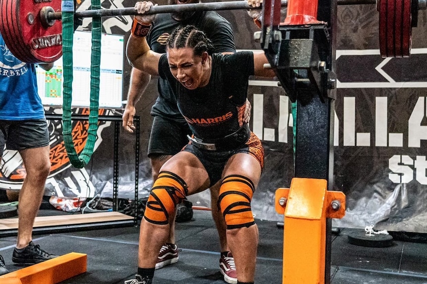 Lily Riley celebrates a successful back squat at a powerlifting competition. 