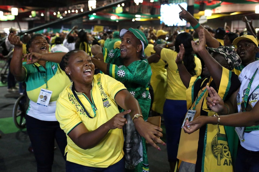 A group of ANC members cheer, dance and throw their hands in the air as they celebrate Cyril Ramaphosa being elected president.