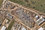 A satellite view of a scrap metal processing site with large stockpiles of metal.