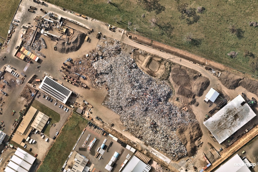 A satellite view of a scrap metal processing site with large stockpiles of metal.