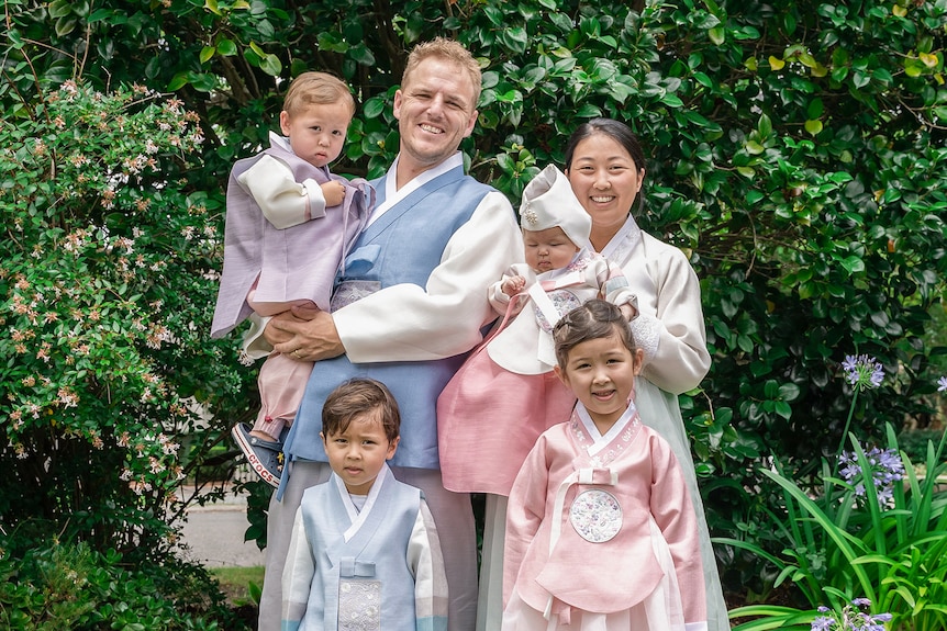 Esther, Andrew and their for your children smile in their traditional Korean Hanbok.