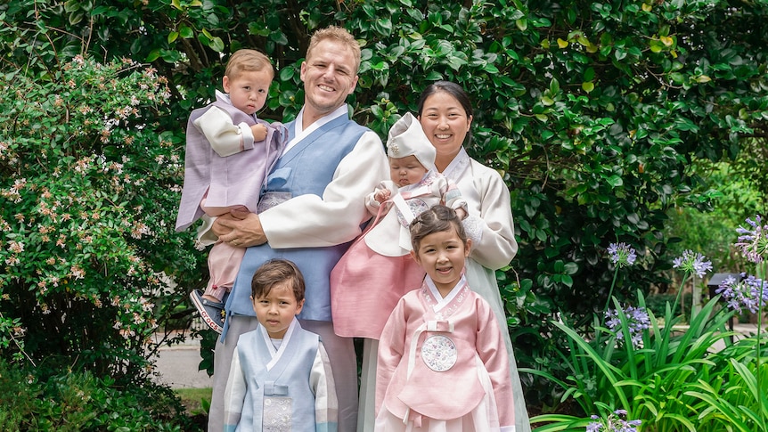 Esther, Andrew and their for your children smile in their traditional Korean Hanbok.