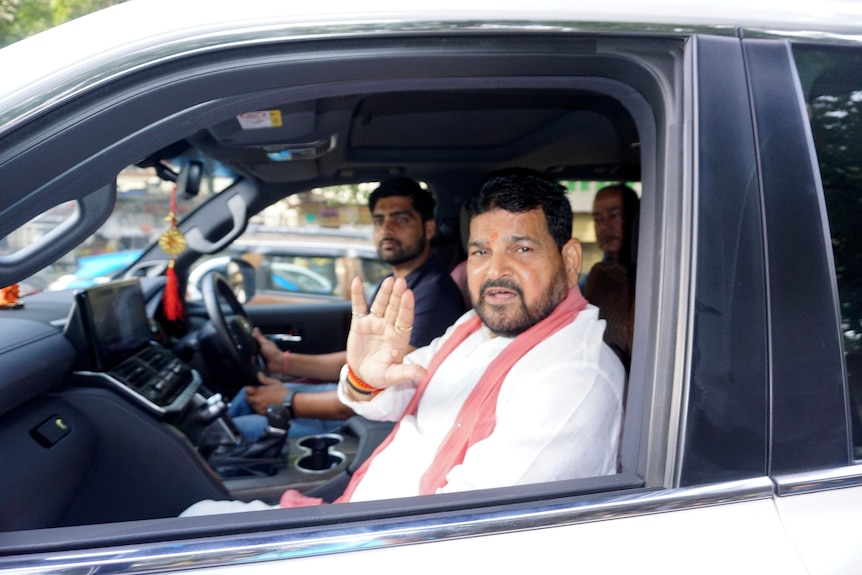 Brij Bhushan Sharan Singh sitting in the passenger seat of a car. 