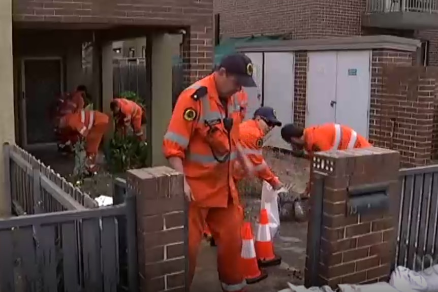 Emergency services sandbagging outside a home.