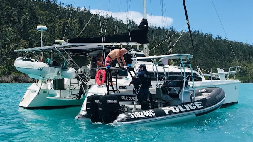 A water police officer talking to a boat owner.