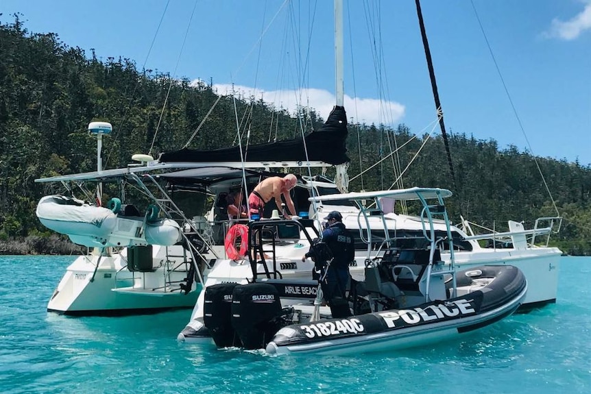 A water police officer talks to a boat owner.