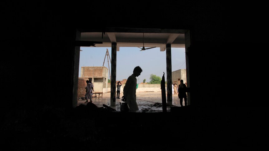 A man walks past a window of the mosque which was hit by the deadly attack