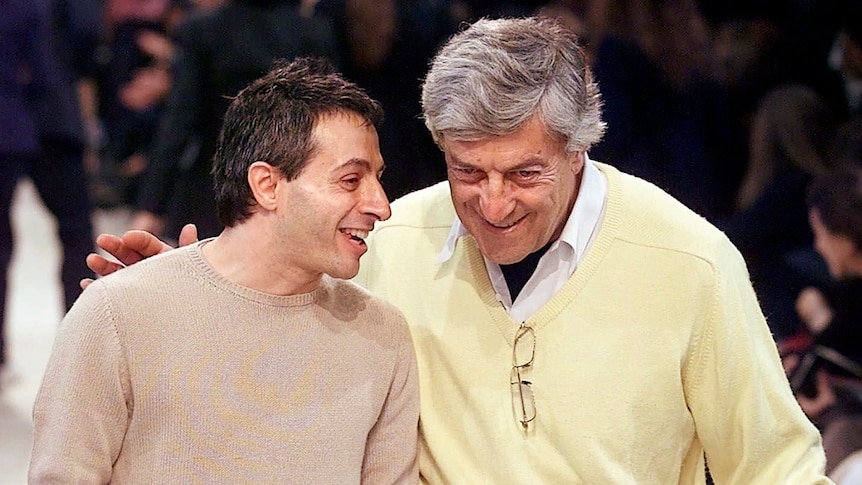 two men on a fashion runway laughing