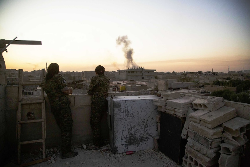 YPJ members look over Raqqa from a house they take as a base