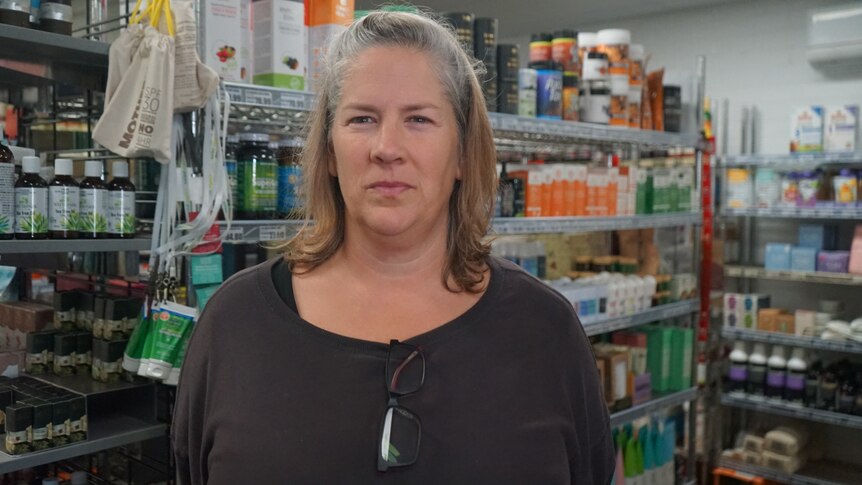 Loren McMath standing in front of shelves in her store.