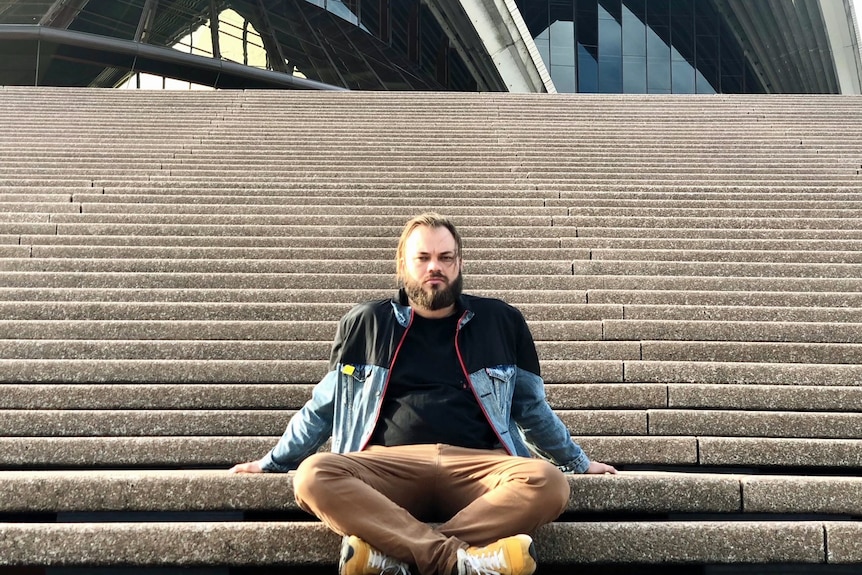 A man sits on the Sydney Opera House steps