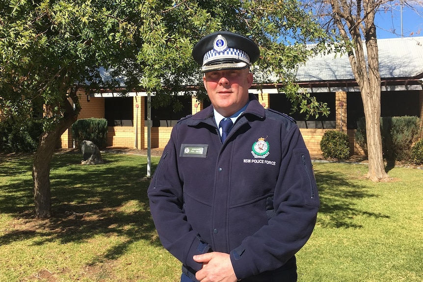 Male police officer dressed in blue uniform with hat