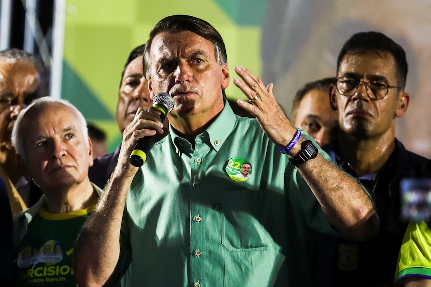 Jair Bolsonaro speaks at a podium at a rally.