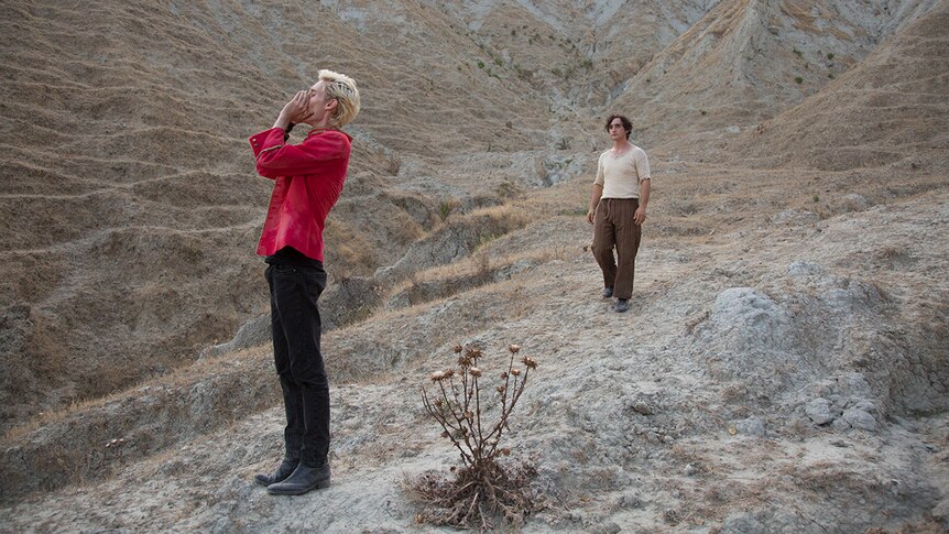 Colour still of Luca Chikovani calling out and Adriano Tardiolo in mountainous landscape in 2018 film Happy as Lazzaro.