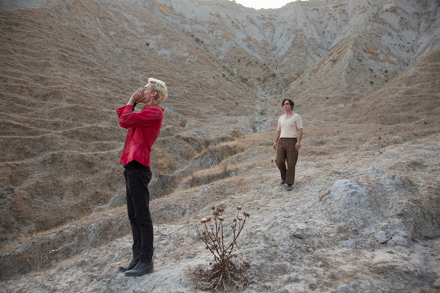 Colour still of Luca Chikovani calling out and Adriano Tardiolo in mountainous landscape in 2018 film Happy as Lazzaro.