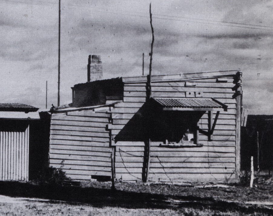 Black and white photo of a rundown shack.