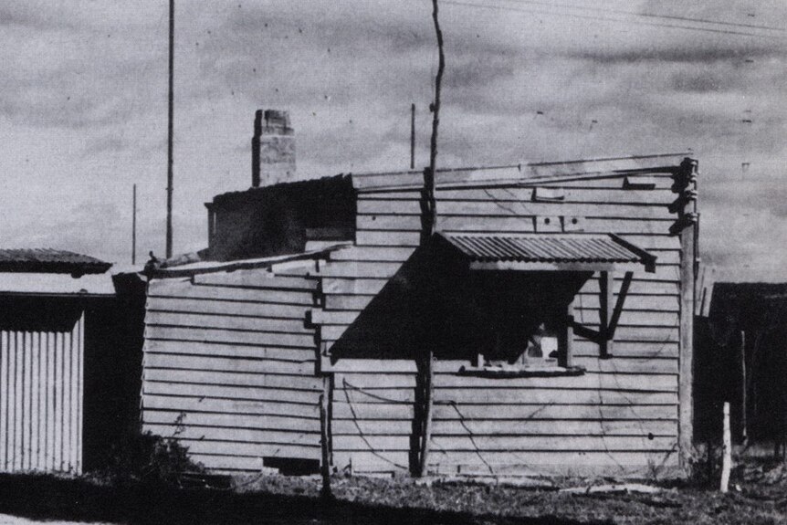Black and white photo of a rundown shack.