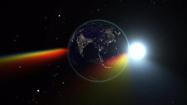 Planet Earth in space, Sun shines behind, rainbow light from Sun bends around Earth