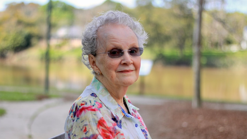 An elderly woman sitting on a park bench