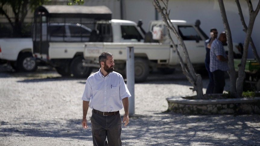 A man walks away from several trucks in a Haitian missionary compound