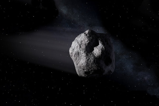 An artist's depiction shows an asteroid drifting through the darkness of space with distant stars shinning in the background