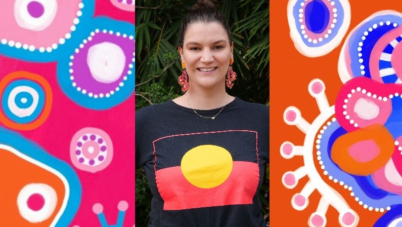 Lady standing between bright Aboriginal artwork.