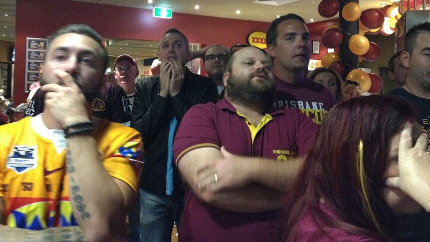 Fans at Broncos leagues club watch in shock as the Cowboys score in the final second of the match.