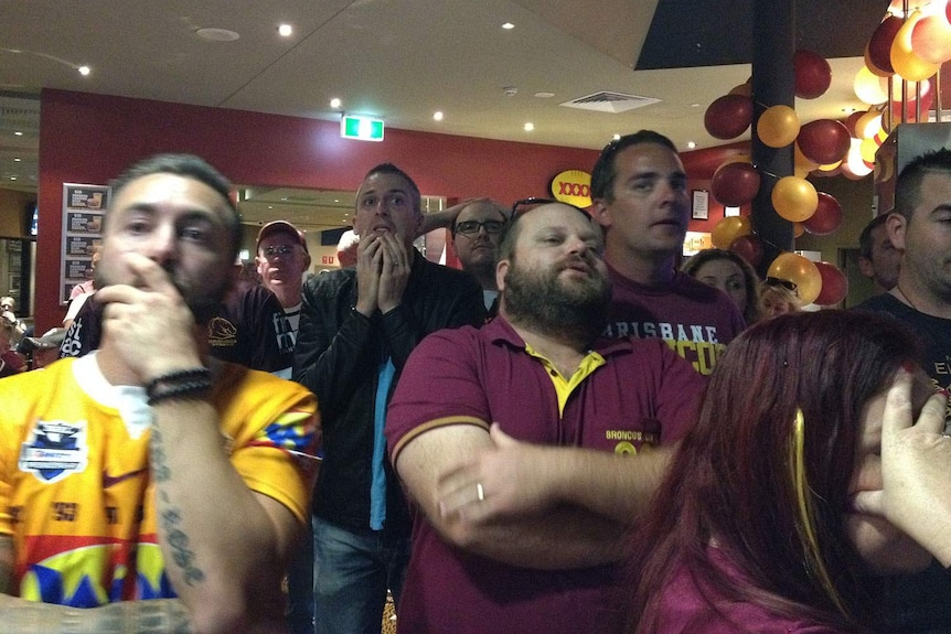 Fans at Broncos leagues club watch in shock as the Cowboys score in the final second of the match.
