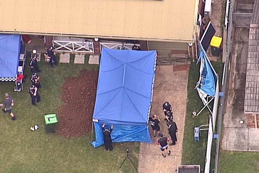 Police stand around a blue tent, under which they dig for the body of Priscilla Brooten or clues about her disappearance.