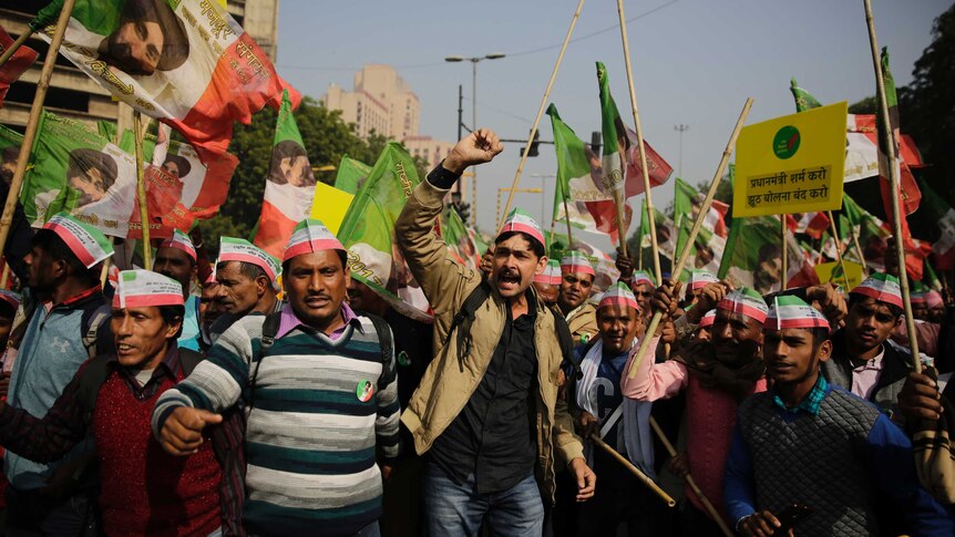 Indian farmers wave flags and shout in protest against low food prices.
