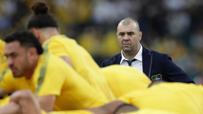 A coach watches his team warm up before the Australia versus England Rugby World Cup match.