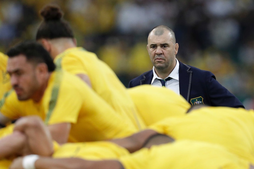 A coach watches his team warm up before the Australia versus England Rugby World Cup match.