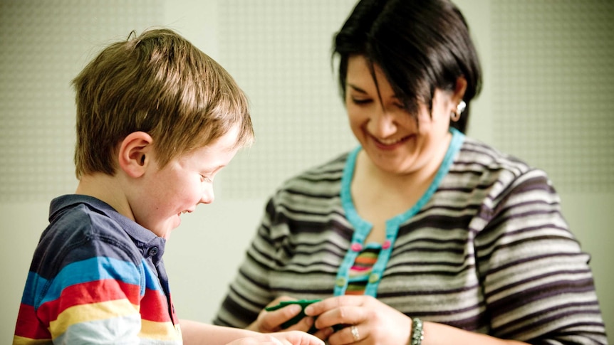 Dr Josephine Barbaro and a young child looking at green cards.