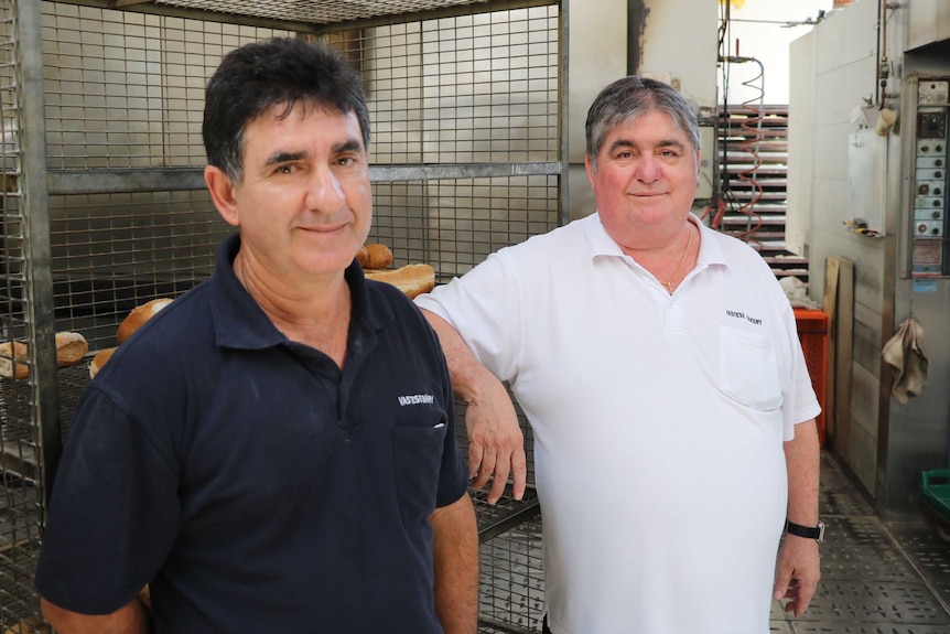 Lou and Antonio Saraceni stand in the kitchen of their North perth bakery, in front of cages and machines.