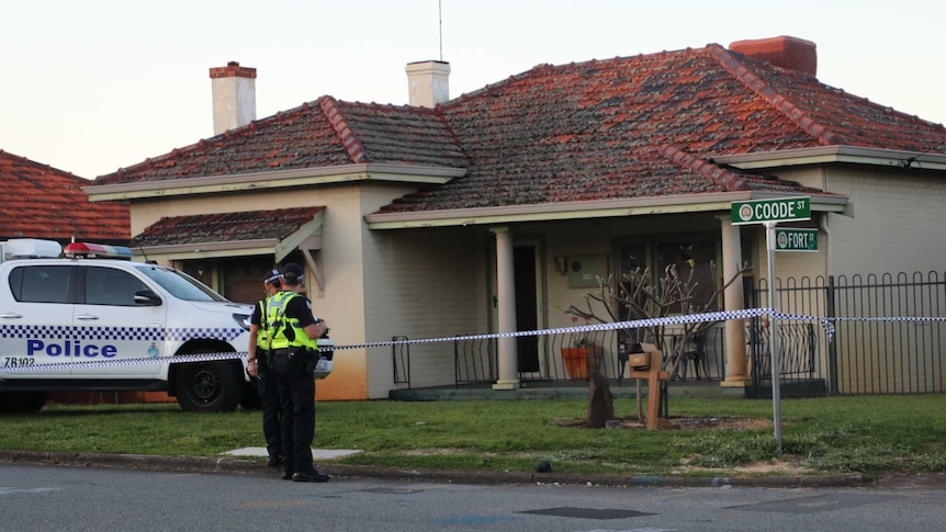 A brick and tile house with police tape, a police car and two officers out the front.