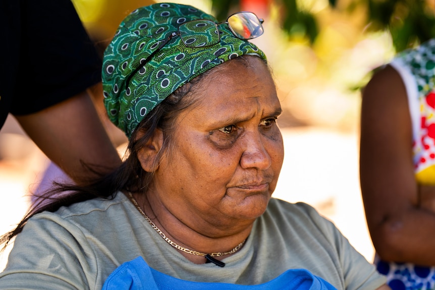 An older Indigenous lady has tears in her eyes