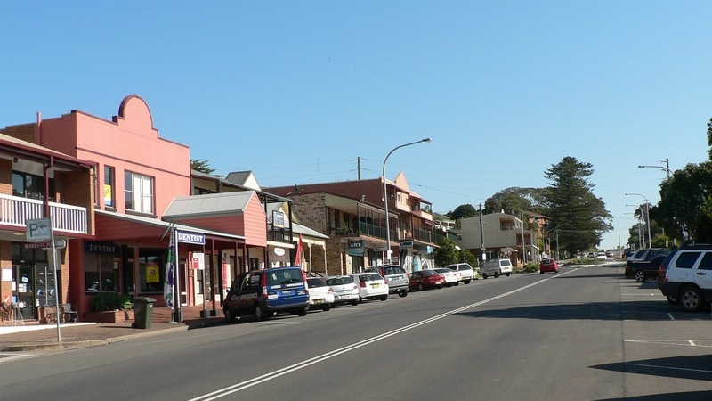 Main street of Kiama showing red brick buildings, a roundabout in the distance