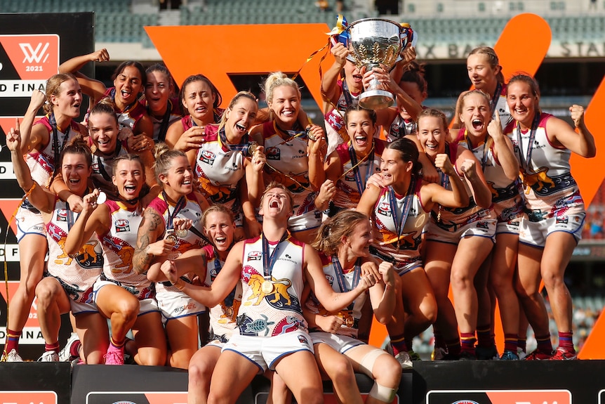Brisbane Lions AFLW players celebrate winning the premiership on the podium at Adelaide Oval