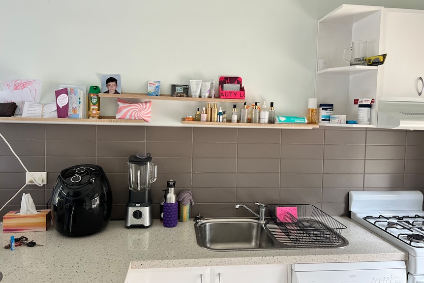 small kitchen with bathroom products displayed on the counter 