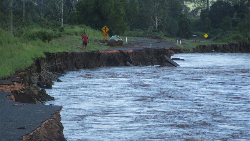 A road is washed away by floodwaters at Mt Sylvia near Gatton