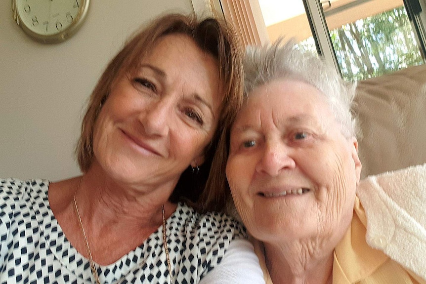 One woman in her sixties pictured smiling in a selfie with another woman in her nineties.