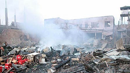 Smoke rises from the debris at the site of the Bali bombings.