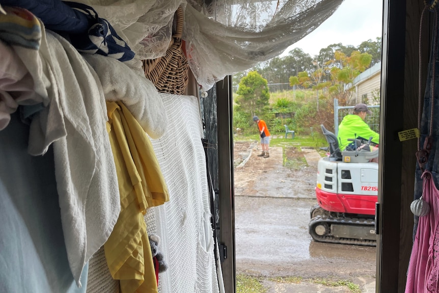 Two workers on site from the view of inside a caravan