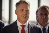 A head and shoulders shot of Richard Marles in a suit and tie speaking at a media conference outdoors.