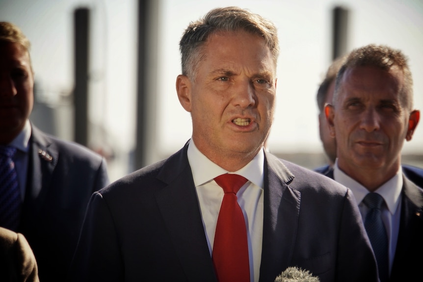 A head and shoulders shot of Richard Marles in a suit and tie speaking at a media conference outdoors.