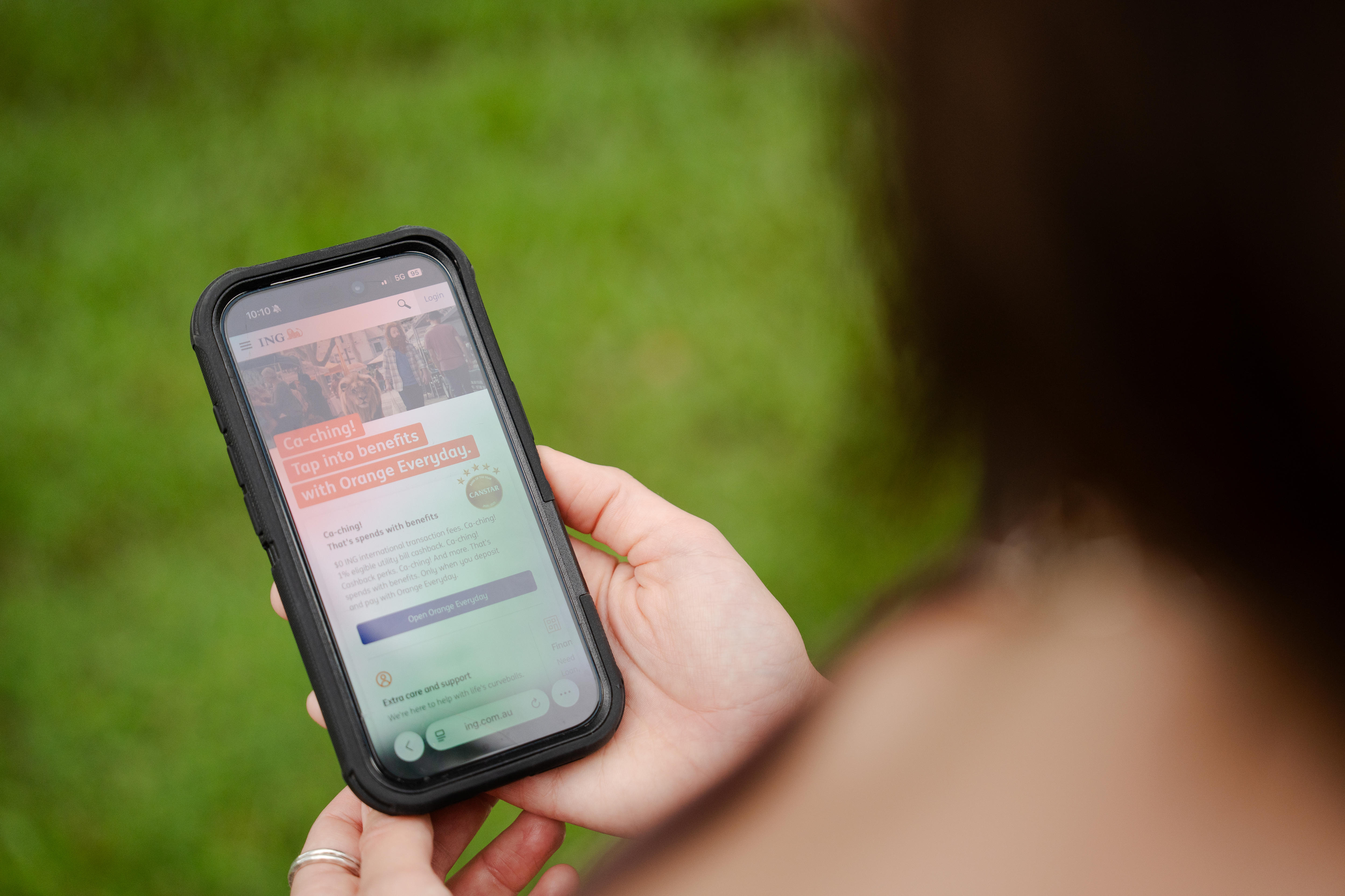 Una mujer mira una aplicación bancaria en su teléfono celular.