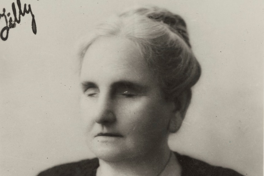 A black and white photo of a woman wearing a black dress.